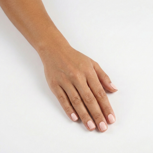 Hand wearing Ballerina soft blush nude nail polish wraps on a plain white background