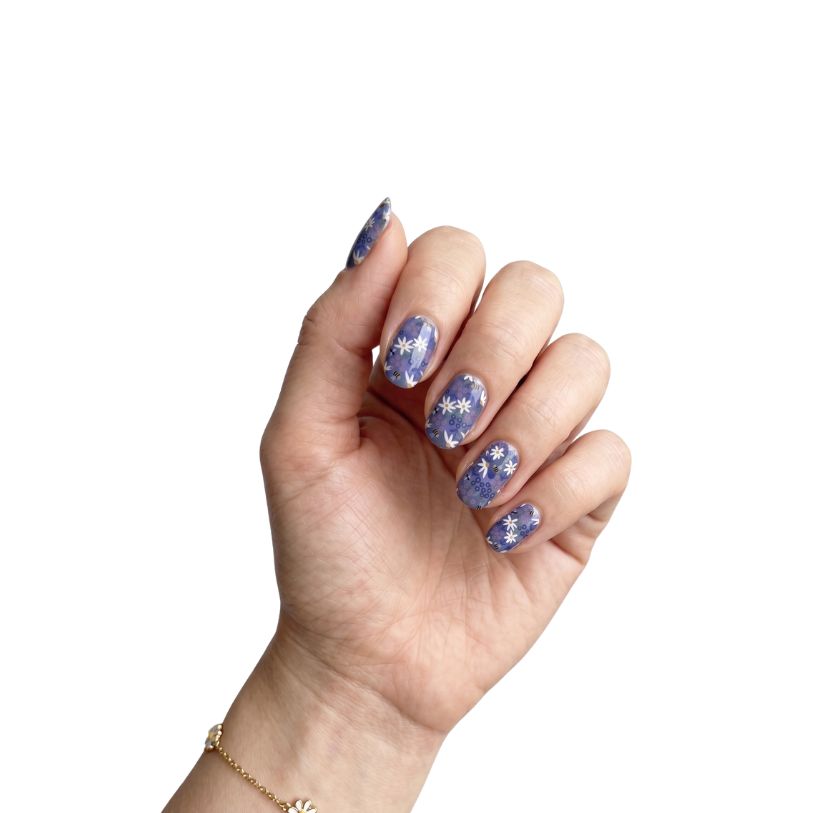 Hand wearing Forget Me Not periwinkle blue floral nail polish wraps