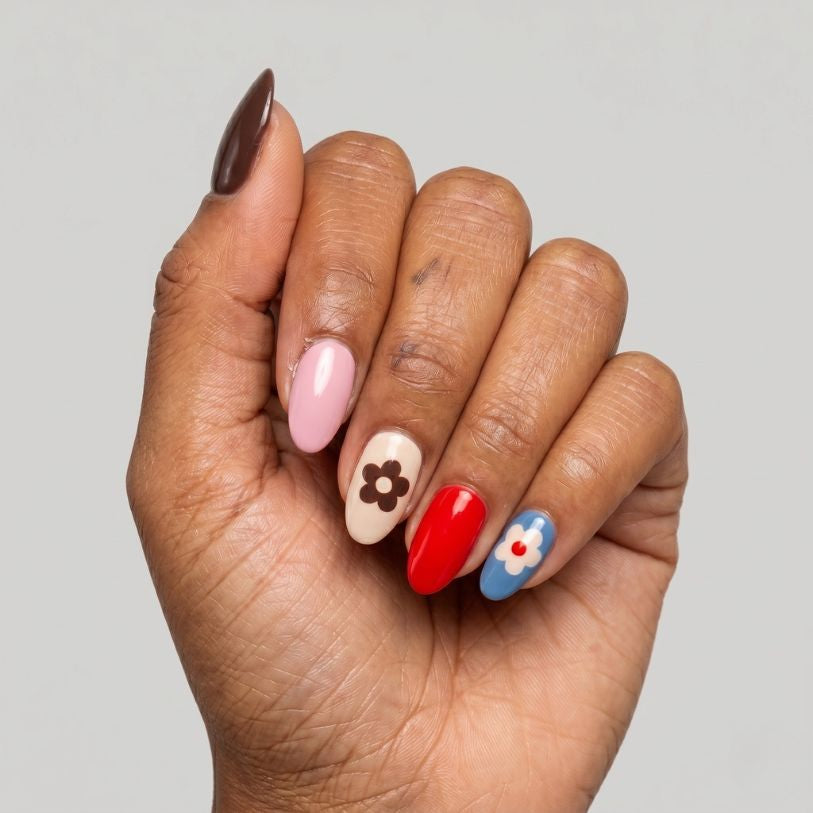 Hand wearing Groovy retro red, pink and brown daisy nail polish wraps