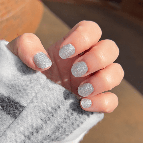 Close-up of fingers wearing Shimmer silver glitter nail polish wraps