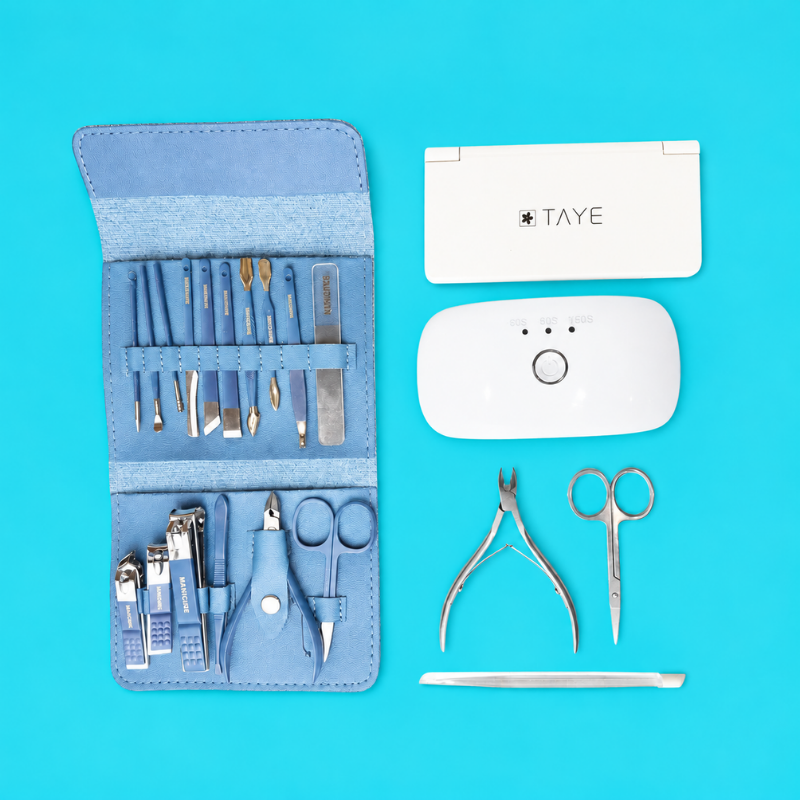 Manicure tool kit, nail clippers and a mini UV/LED lamp on blue