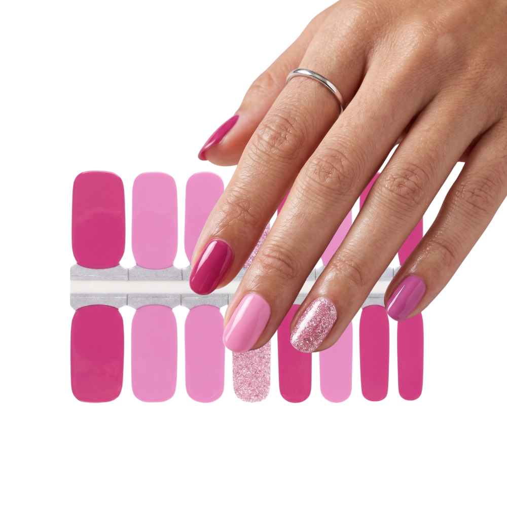 Hand wearing Lola pink nail polish wraps above the 16-strip wrap sheet